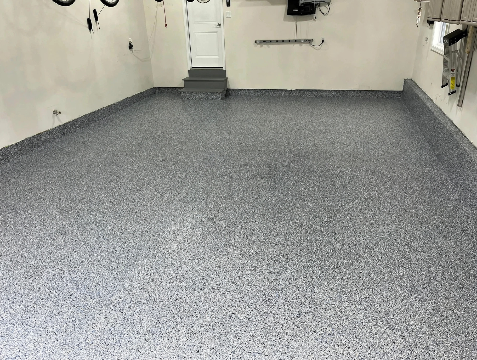 Finished light-colored garage floor with decorative epoxy flakes